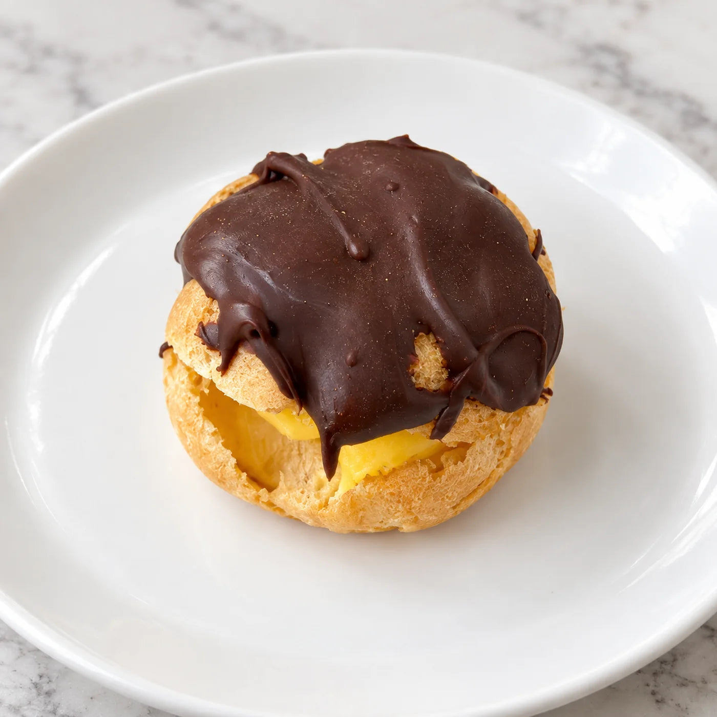 Italian cream puff filled with vanilla custard and capped with a thick layer of dark chocolate