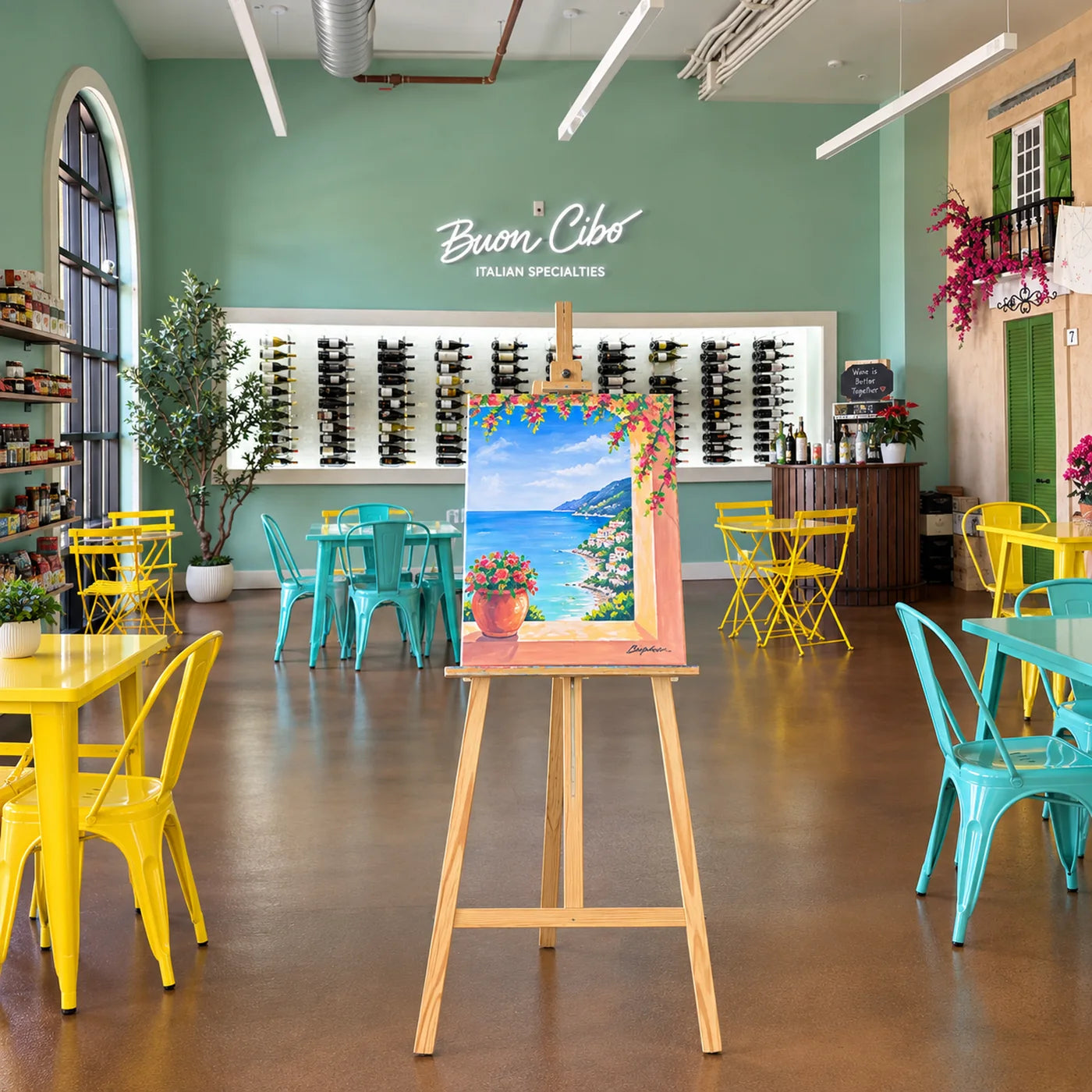 An easel holding a finished coastal painting in the Buon Cibo dining room, set up for a Paint & Sip night in front of the wine wall