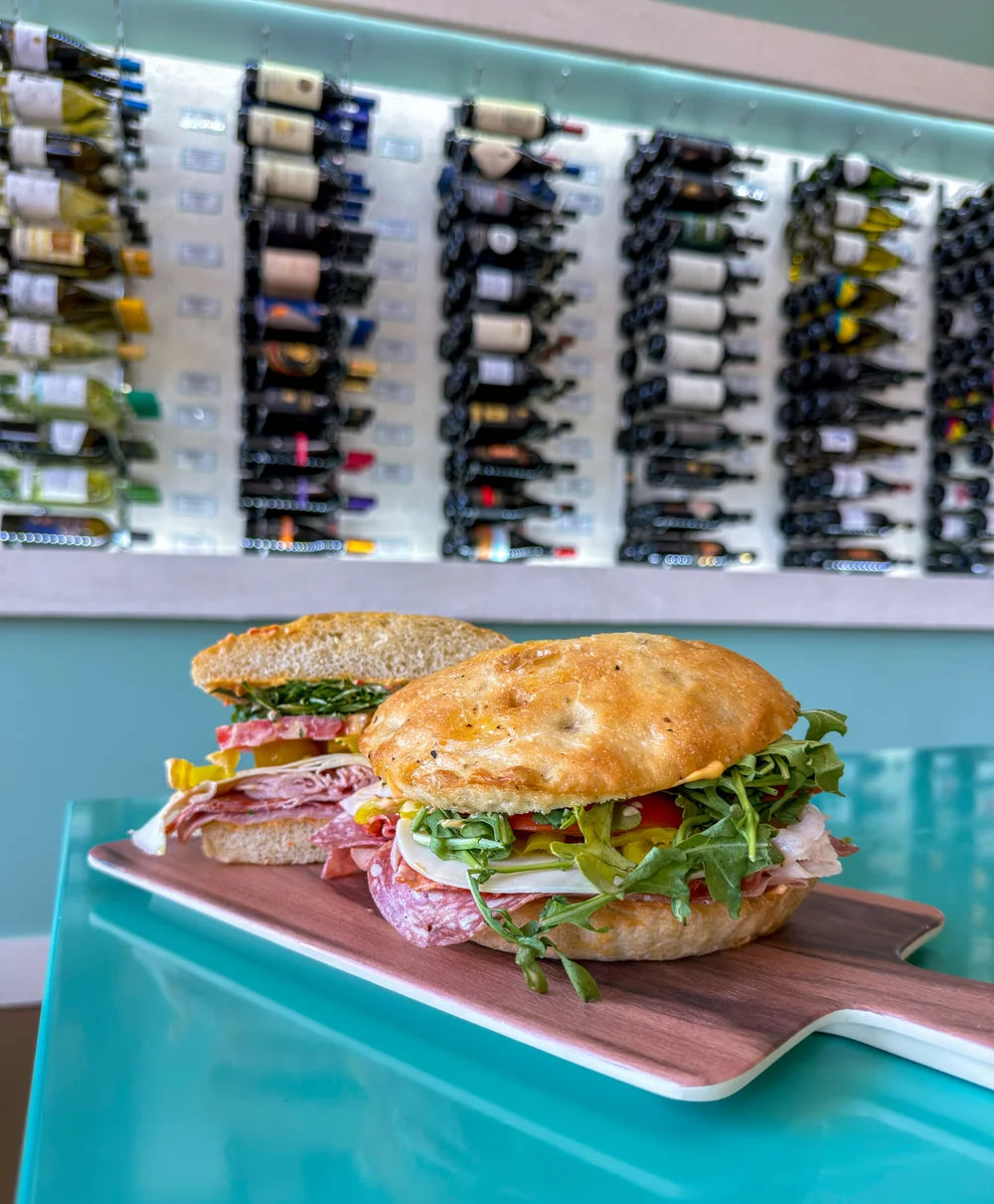 An Italian sandwich photographed beside the wine wall at Buon Cibo